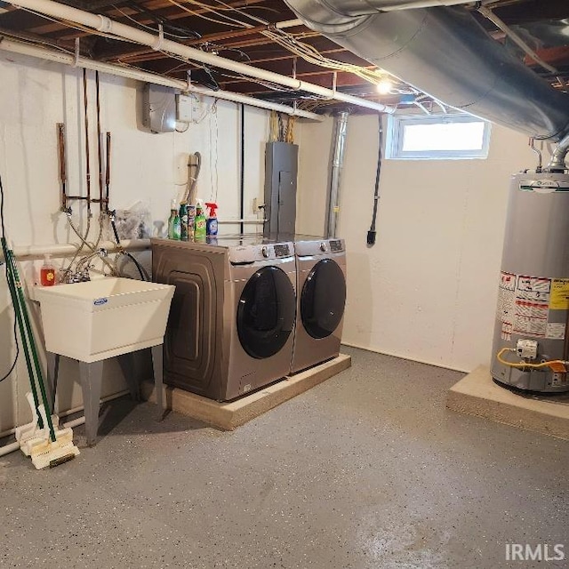 clothes washing area featuring gas water heater, electric panel, washing machine and clothes dryer, and laundry area