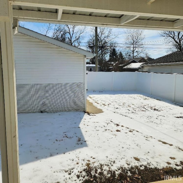 yard covered in snow with a fenced backyard