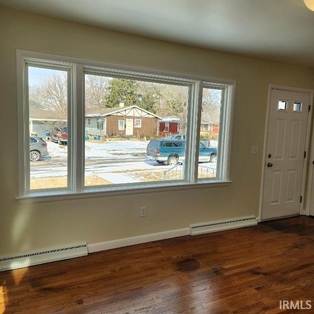 entryway with a baseboard heating unit, dark wood finished floors, and baseboards