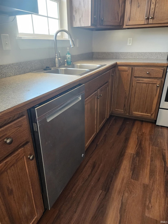 kitchen with dark wood-type flooring, a sink, light countertops, brown cabinets, and dishwasher