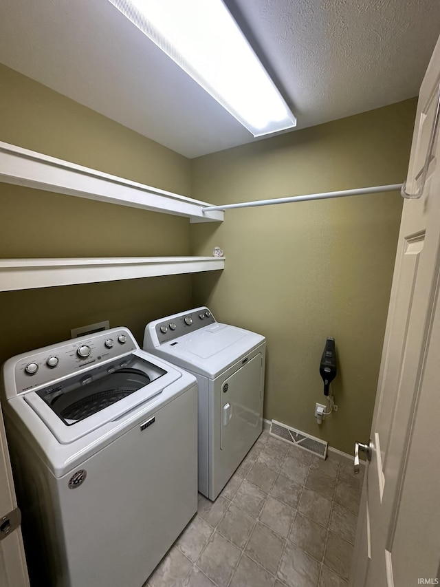 washroom with visible vents, a textured ceiling, laundry area, independent washer and dryer, and baseboards