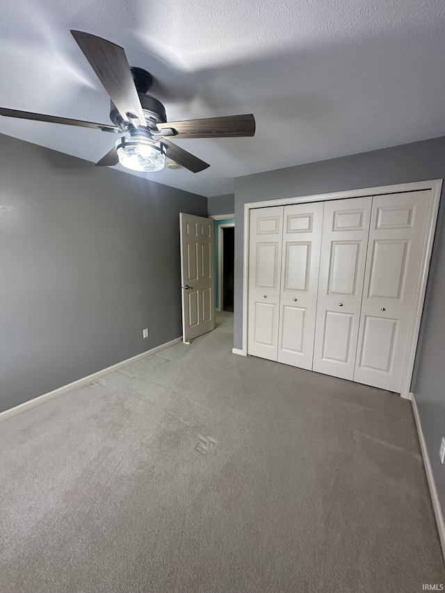 unfurnished bedroom with a ceiling fan, carpet, a closet, and baseboards