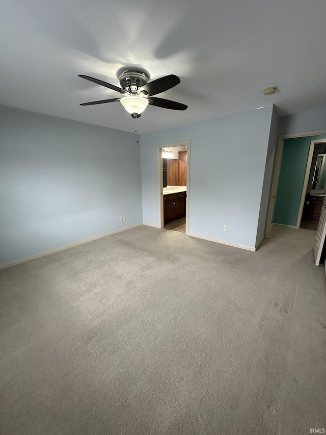 empty room with a ceiling fan, light carpet, and baseboards