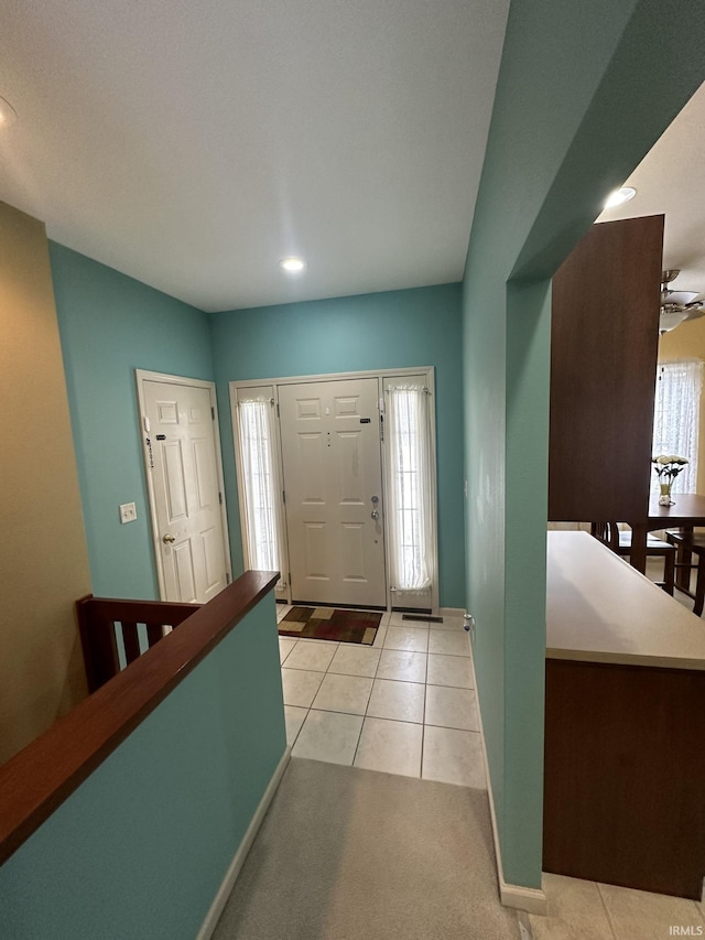 foyer entrance with recessed lighting, baseboards, light colored carpet, and light tile patterned flooring