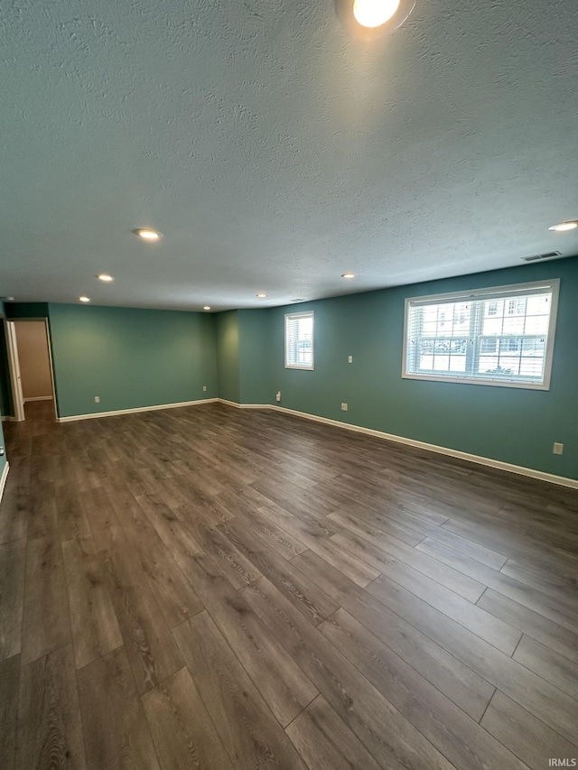 interior space featuring recessed lighting, visible vents, a textured ceiling, wood finished floors, and baseboards