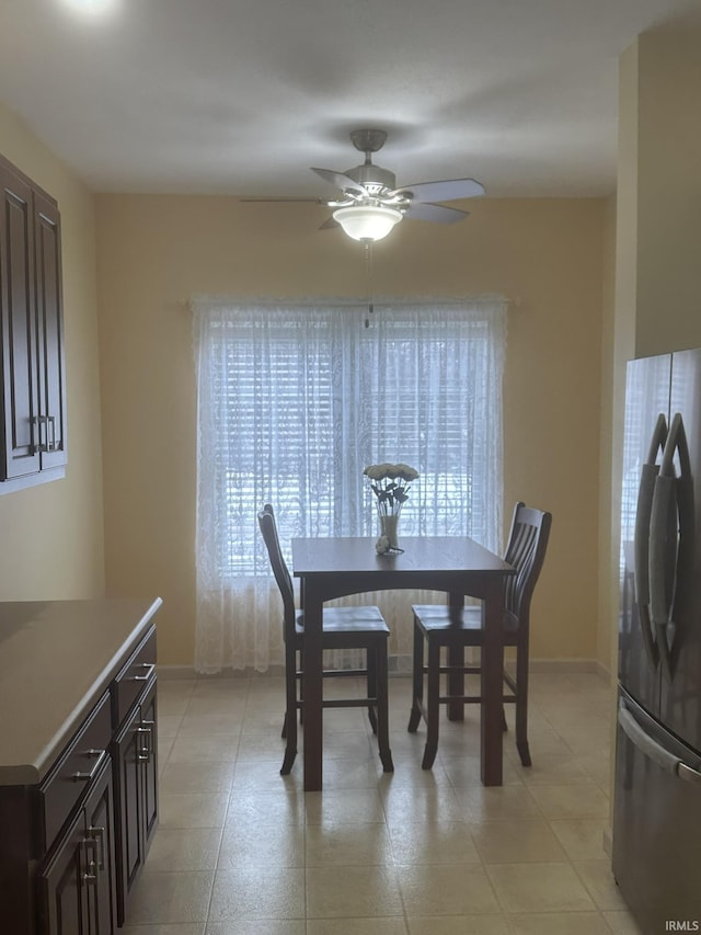 dining space featuring ceiling fan and baseboards