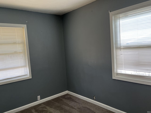 spare room featuring carpet flooring and baseboards