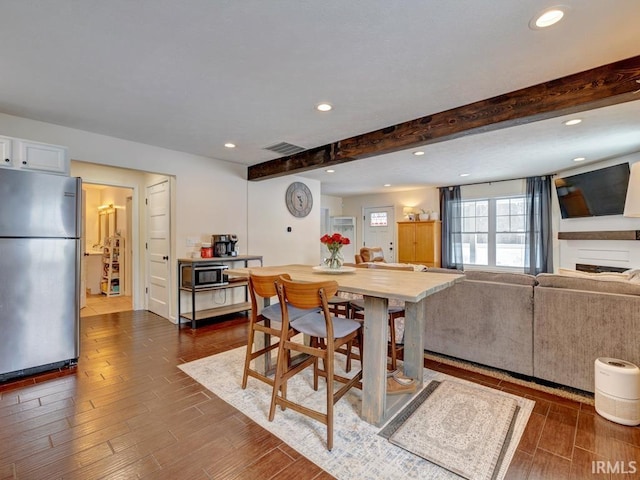 dining space featuring beam ceiling, dark wood-style flooring, visible vents, and recessed lighting