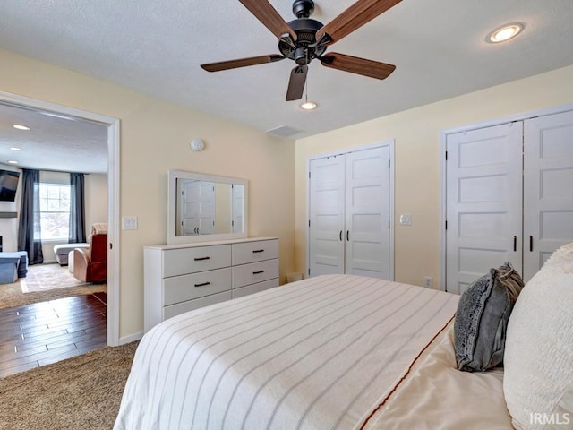 bedroom featuring baseboards, carpet flooring, multiple closets, and recessed lighting