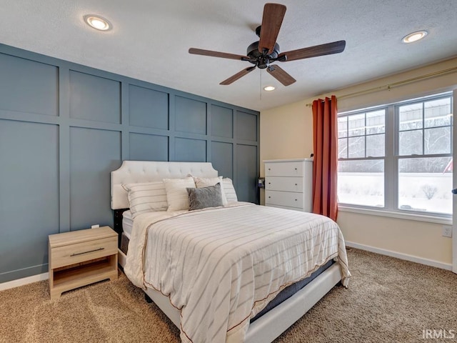 bedroom with recessed lighting, a decorative wall, a ceiling fan, baseboards, and carpet