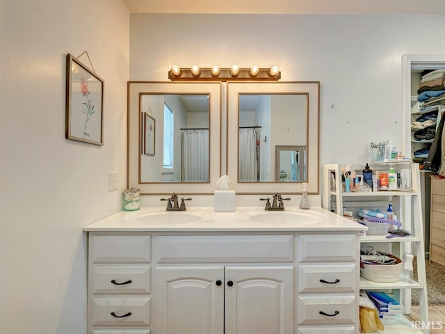 full bath featuring a sink, a shower with shower curtain, and double vanity