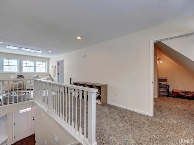 hall with attic access, baseboards, carpet flooring, an upstairs landing, and recessed lighting