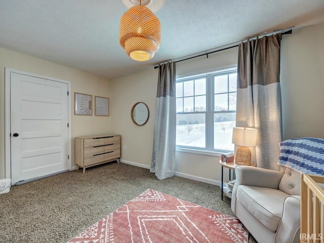 living area featuring carpet flooring, a textured ceiling, and baseboards