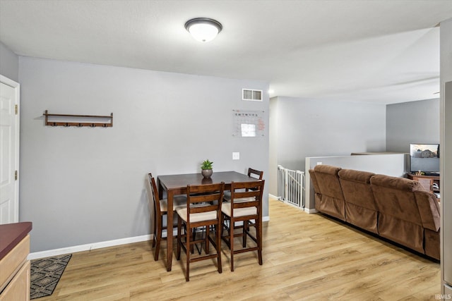 dining space featuring light wood-style floors, baseboards, and visible vents