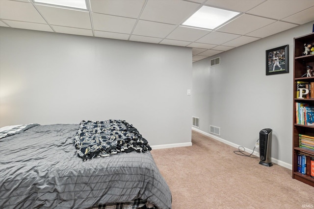 carpeted bedroom featuring a paneled ceiling, visible vents, and baseboards