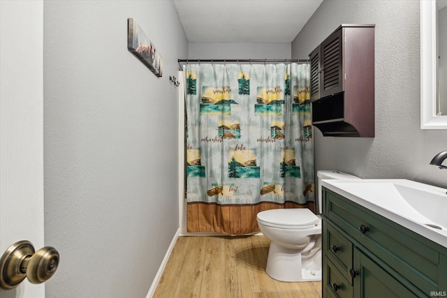 full bath with baseboards, vanity, toilet, and wood finished floors