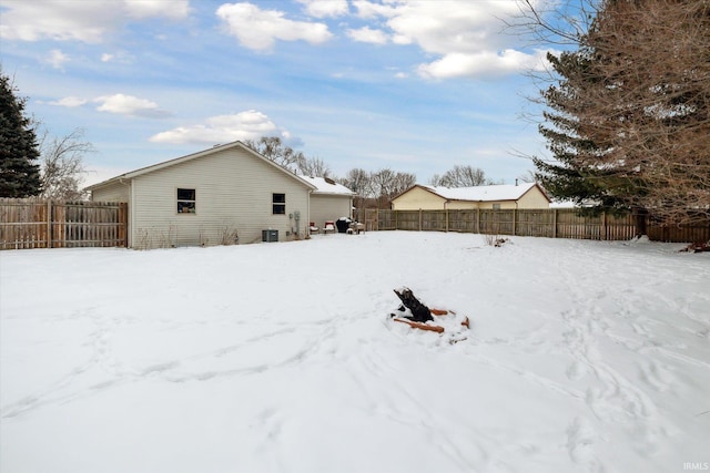 snowy yard featuring fence and central AC unit