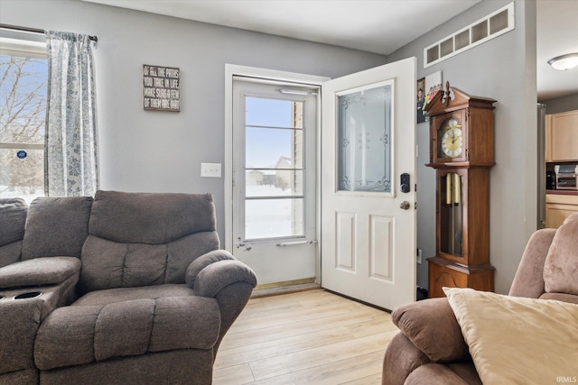 living room with light wood-style floors and visible vents