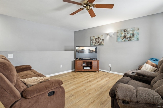 living room with light wood-style flooring, baseboards, and a ceiling fan