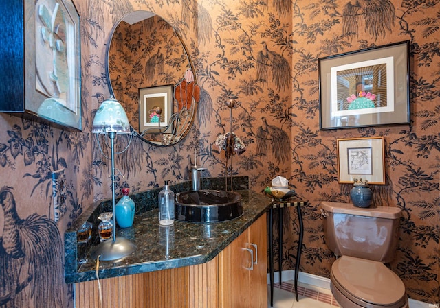 bathroom featuring toilet, vanity, baseboards, and tile patterned floors