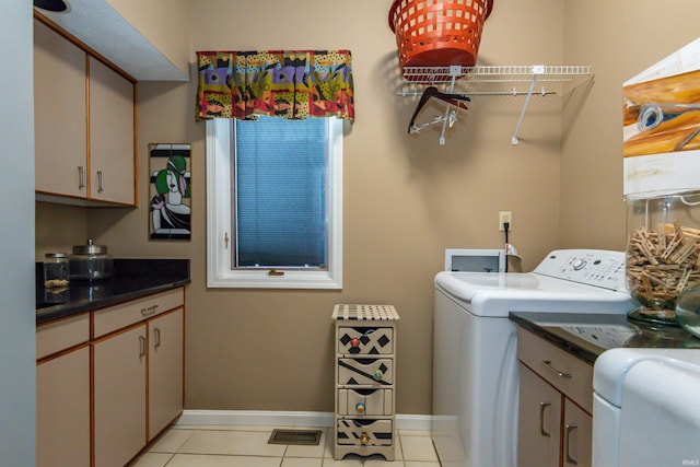 washroom with cabinet space, visible vents, baseboards, washing machine and dryer, and light tile patterned flooring