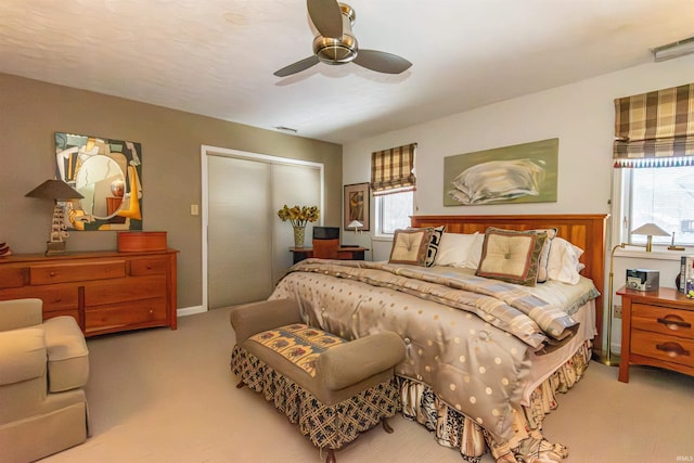 carpeted bedroom featuring visible vents, a ceiling fan, and a closet