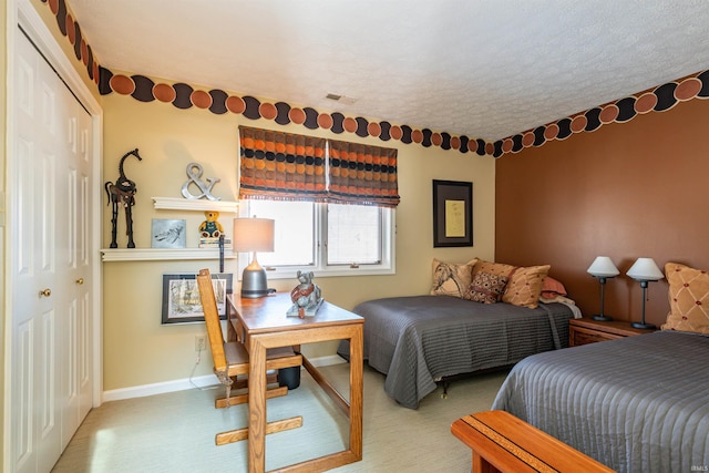 bedroom featuring baseboards, a textured ceiling, visible vents, and a closet