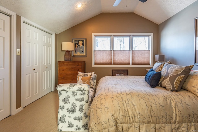 bedroom featuring lofted ceiling, a closet, carpet flooring, and a textured ceiling