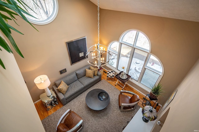 living room featuring lofted ceiling, a notable chandelier, and wood finished floors