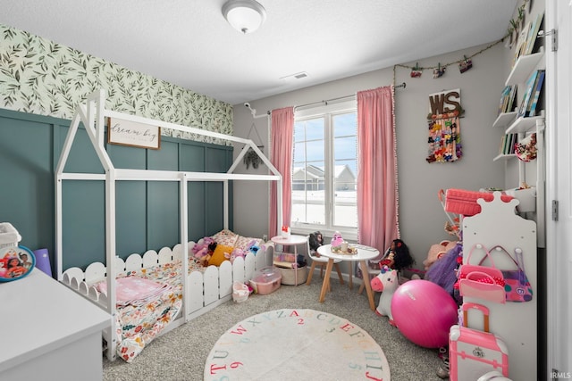 carpeted bedroom featuring visible vents, a textured ceiling, and wallpapered walls