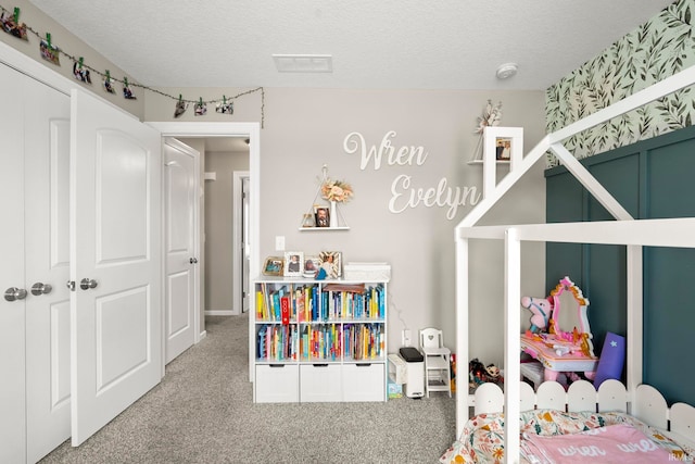 bedroom featuring carpet, visible vents, and a textured ceiling