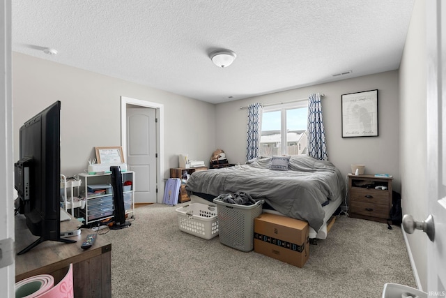 bedroom with carpet floors, visible vents, and a textured ceiling