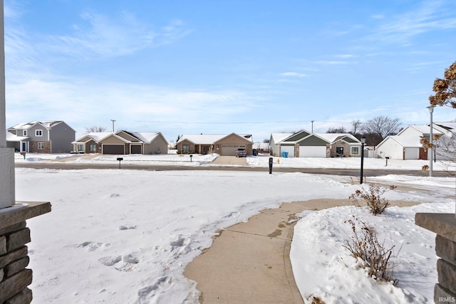 yard covered in snow with a garage and a residential view