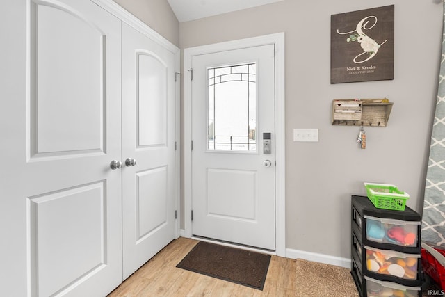 doorway to outside with light wood-type flooring and baseboards