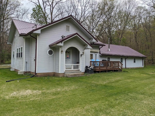 view of front of house with a deck, metal roof, and a front yard