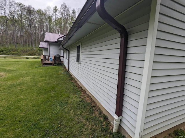 view of side of home with metal roof and a lawn