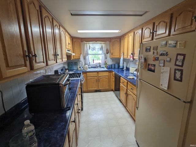 kitchen featuring black dishwasher, light floors, stainless steel stove, freestanding refrigerator, and under cabinet range hood