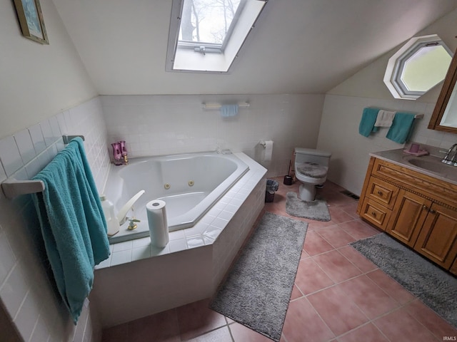 bathroom featuring vaulted ceiling with skylight, tile patterned flooring, toilet, vanity, and a whirlpool tub