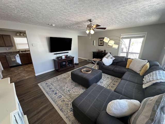 living area with a ceiling fan, baseboards, dark wood finished floors, and a textured ceiling