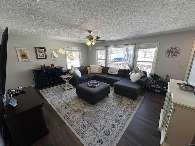 living area with a textured ceiling, dark wood-style flooring, and a ceiling fan