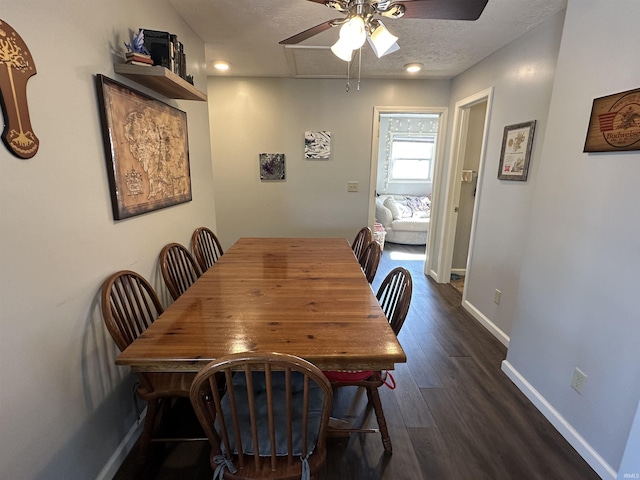 dining room featuring dark wood finished floors, a textured ceiling, baseboards, and ceiling fan