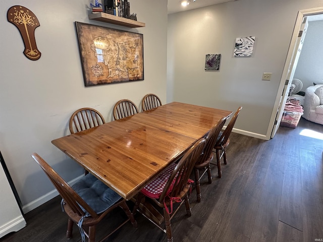 dining room with dark wood-type flooring and baseboards