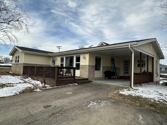 view of front of property with a porch, aphalt driveway, and a carport