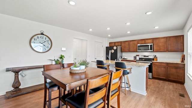 dining area with light wood finished floors, visible vents, and recessed lighting