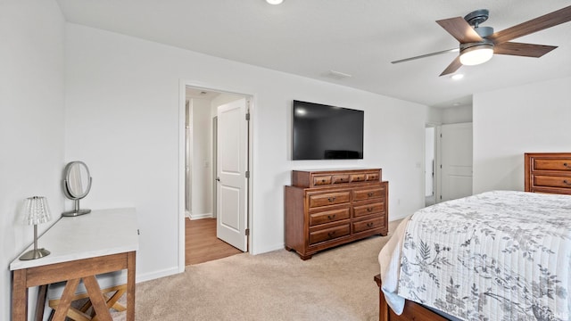 bedroom featuring a ceiling fan, light carpet, and baseboards