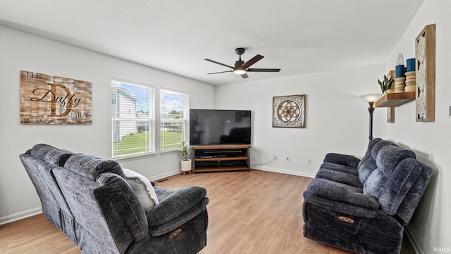 living area with ceiling fan, light wood-style flooring, and baseboards