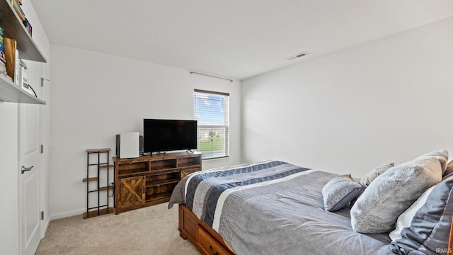 bedroom with light colored carpet, visible vents, and baseboards