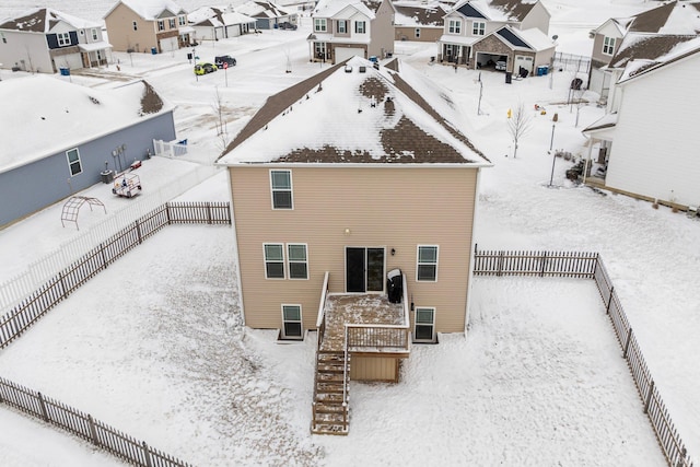 snow covered property featuring a residential view and fence