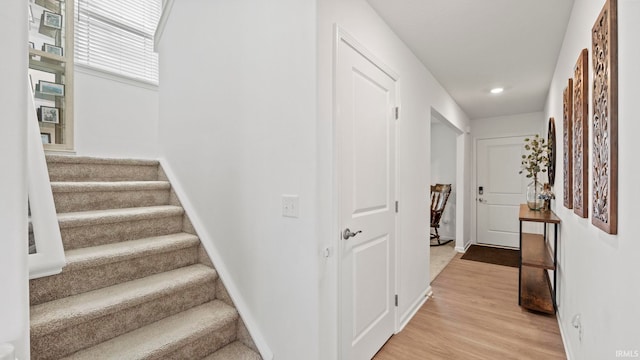 stairway with baseboards and wood finished floors