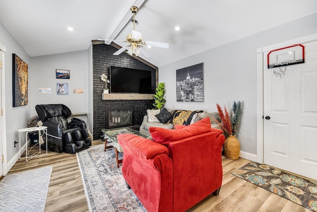 living area with vaulted ceiling with beams, a fireplace, wood finished floors, and a ceiling fan